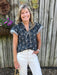 This versatile top combines feminine details with everyday wearability. Ruffled cap sleeves and a tie neckline with coordinating ruffles bring texture and movement, while the navy and white striped trim against the navy fabric creates a crisp, classic contrast. Style it with white pants, shorts, or your favorite denim for a super cute summer outfit! Looks great untucked, tucked or just front tucked.

Carolee is wearing a Small.

Material: 100% Cotton

Care Instructions: Hand wash cold, hang to dry