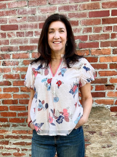 This is such a sweet and feminine top that's perfect for warm summer days! The cream fabric is soft and light weight. The front is lined. The floral pattern is in soft muted tones and the sleeves have a slight puff. It has a V-neck with a lace placket.

Tara is wearing a small.

Material: 70% Rayon / 30% Nylon: Lining: 100% Polyester

Care Instructions: Hand wash cold, hang to dry