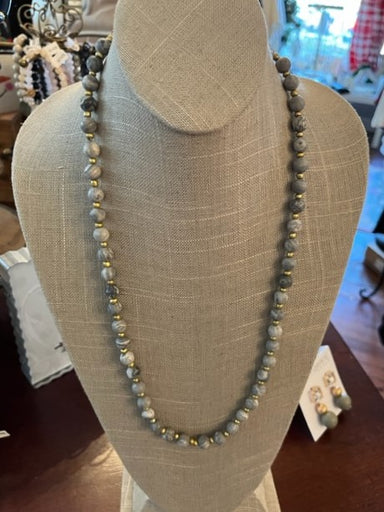 This Long Stone and Beaded Necklace is a stunning winter statement piece. Perfectly balanced to pair with your favorite winter sweater, the beautifully crafted combination of gray stone beads and smaller gold beads will add a dazzling touch to any look.   Approximate Length: 32-35"