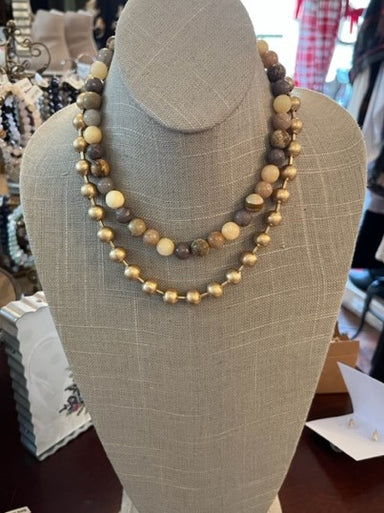 This double stranded beaded necklace is the perfect combination of luxury and natural beauty. With one strand of golden beads and a second of natural, earth-tone beads, this stunning accessory will take your breath away!   Approximate Length: 16-19"
