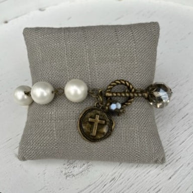 This beautiful Pearl & Crystal Beaded Bracelet w/ Cross Charm will help you express your faith in an elegant and stylish way. Featuring a T-bar closure, antique gold accents, and a round disc with a cross emblem, it adds a sophisticated touch to any outfit. Its combination of colored and crystal beads creates an eye-catching shimmer!