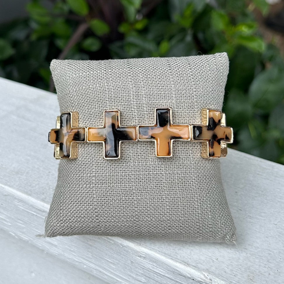 Elegant cross-shaped links in rich tortoise tones create a striking design on this comfortable stretch bracelet. The flexible fit adjusts to your wrist for all-day wear, while the distinctive cross motifs add spiritual or fashion-forward appeal. Perfect for layering or wearing solo.

Pair with our matching cross necklace.