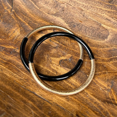 The Leo Black &amp; Gold Bangle Bracelet Set brings timeless elegance to your jewelry collection. Layer these striking bangles for maximum impact or wear individually for refined simplicity. The perfect blend of black and gold creates a modern aesthetic that complements any style—from casual weekend looks to sophisticated evening wear. Effortlessly transitions from day to night, making it an essential accessory for every wardrobe.