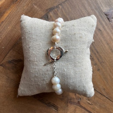 Elevate your style with our timeless Pearl Bracelet! The simple, elegant design features a T-bar closure with a heart for added charm. Made with silver hardware and a delicate pearl bracelet, it's the perfect accessory for any occasion.