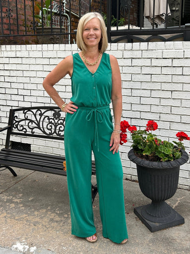 How flattering and cute is this sleeveless knit jumpsuit in rich pine green! The fabric is amazing... a soft, lightweight knit. The jumpsuit features a flattering V-neckline and button-up bodice with an elastic waist and an adjustable tie. Whether you're heading to brunch, running errands, or enjoying a casual evening out, this versatile piece works beautifully on its own or layered under a denim jacket when temperatures drop.&nbsp;

Barbara is wearing a small.&nbsp;

Material: 48% Rayon / 36% Polyester / 1