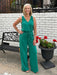 How flattering and cute is this sleeveless knit jumpsuit in rich pine green! The fabric is amazing... a soft, lightweight knit. The jumpsuit features a flattering V-neckline and button-up bodice with an elastic waist and an adjustable tie. Whether you're heading to brunch, running errands, or enjoying a casual evening out, this versatile piece works beautifully on its own or layered under a denim jacket when temperatures drop.&nbsp;

Barbara is wearing a small.&nbsp;

Material: 48% Rayon / 36% Polyester / 1
