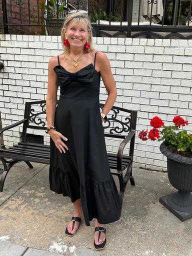 We love this black sundress with its cute bow and sweet style! Delicate spaghetti straps frame the shoulders while the high bodice provides structure and flattering support. Cascading skirt with a tier create beautiful movement and visual interest throughout the skirt, while a charming front bow adds a playful touch that sets this dress apart. Hidden side pockets offer functional convenience, and the back zipper closure ensures a smooth, polished fit. Whether you're heading to brunch, a casual date, or week