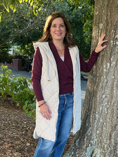The Long Quilted Puffer Hoodie Vest in Ivory is the perfect layering piece for any season. This versatile vest features a quilted puffer design that provides lightweight warmth without bulk. The full zip front allows for easy on-and-off, while the adjustable hood adds extra coverage and style. Ivory's neutral tone pairs effortlessly with any wardrobe, making it ideal for casual outings, outdoor activities, or everyday comfort. Whether worn over a sweater or lightweight top, this vest delivers both functiona