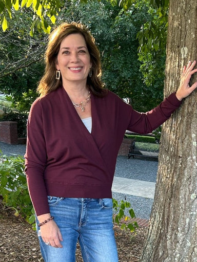 Drape yourself in effortless elegance with this Soft Fine Knit Wrap Sweater in rich gemstone burgundy. The lightweight knit delivers cozy comfort without bulk, while the unique front wrap silhouette creates a flattering fit. Perfect as a versatile transition piece that layers beautifully with skirts or pairs with your favorite jeans for polished, everyday style.