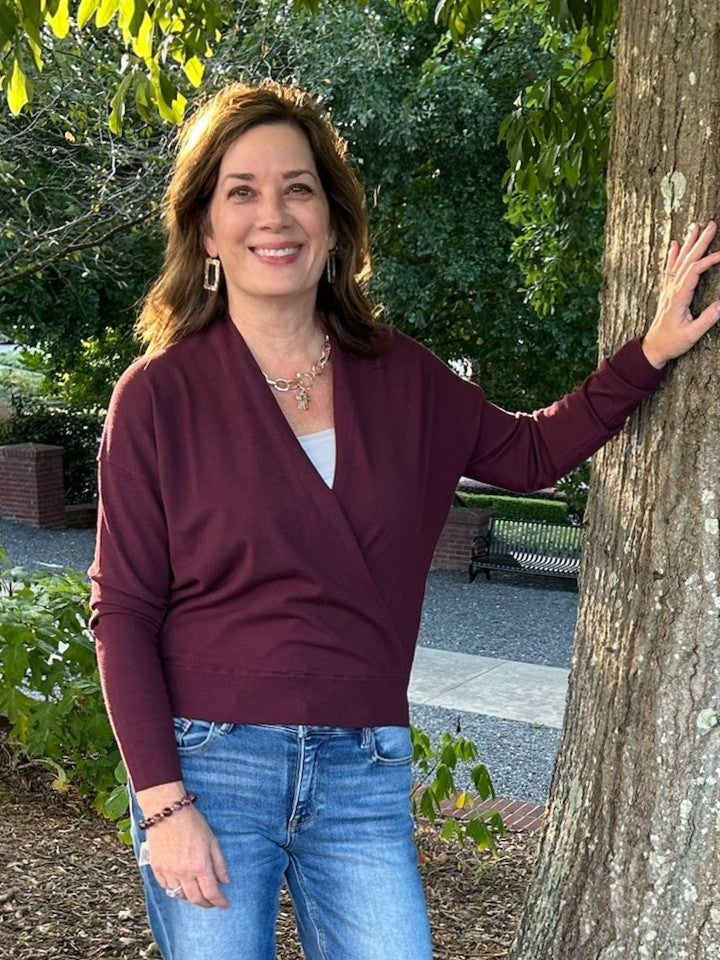 Drape yourself in effortless elegance with this Soft Fine Knit Wrap Sweater in rich gemstone burgundy. The lightweight knit delivers cozy comfort without bulk, while the unique front wrap silhouette creates a flattering fit. Perfect as a versatile transition piece that layers beautifully with skirts or pairs with your favorite jeans for polished, everyday style.