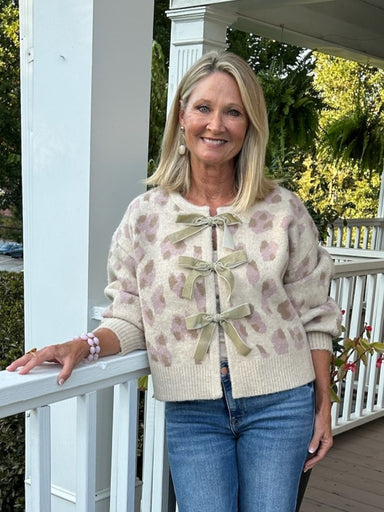 Fun leopard print jacquard cardigan with playful front bow details. The two-tone color mix works equally well dressed up or down—pair with jeans for casual charm or with a matching skirt for sophistication. Soft, versatile piece that adds personality to any wardrobe.