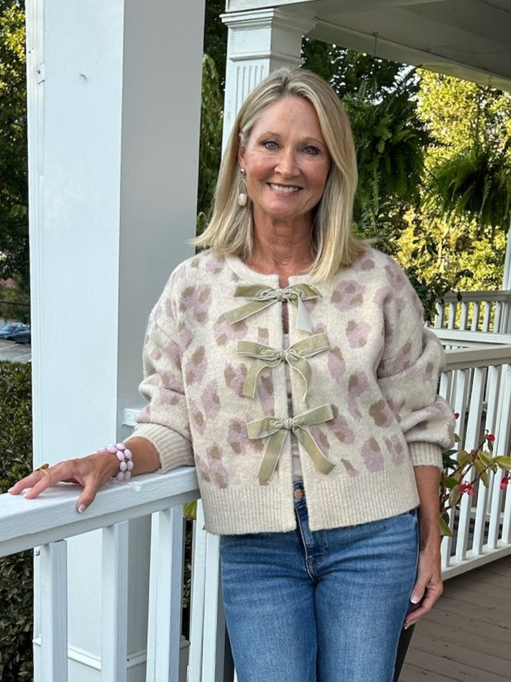Fun leopard print jacquard cardigan with playful front bow details. The two-tone color mix works equally well dressed up or down—pair with jeans for casual charm or with a matching skirt for sophistication. Soft, versatile piece that adds personality to any wardrobe.