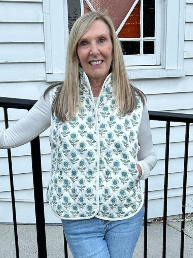 A cozy quilted vest that layers beautifully with everything in your closet. Features a charming floral print, snap-up front closure, and practical side pockets. Wear it over your favorite tee, pair with jeans or a flowy skirt, or layer under a jacket for extra warmth.