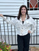 A wardrobe essential that works as hard as you do. This cream utility jacket combines effortless style with practical design. The soft fabric drapes beautifully while the stand-up collar and zip front with snap placket deliver contemporary edge. Drawstring waist cinches for a flattering silhouette, and adjustable tie cuffs at the wrists ensure a perfect fit every time. Long sleeves provide coverage, while the neutral tone makes it the perfect layer for any season or occasion.