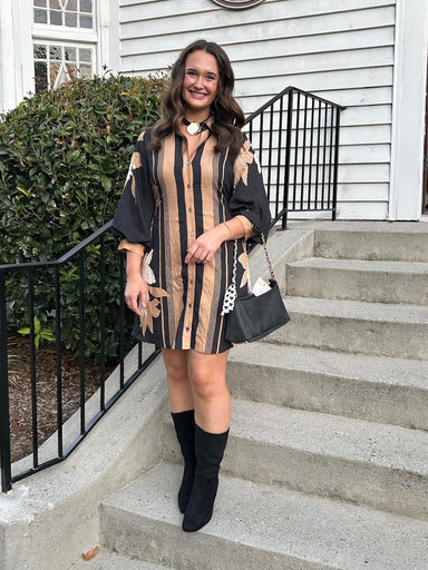 A sophisticated button-up dress featuring a striking black and camel color design. The lined silhouette showcases 3/4 balloon sleeves for elegant volume and movement. Cinch the included tie belt at the back or front for a custom fit. Style with black boots or heels for a polished, versatile look.