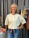 A versatile button-down sweater crafted from lightweight fabric, perfect for layering and transitioning between seasons. Available in two sophisticated color options—cream and pink—each designed to complement a range of styling choices. Pair with your favorite scarf or necklace to elevate any look. The relaxed fit and refined construction make this piece a wardrobe essential for effortless sophistication.