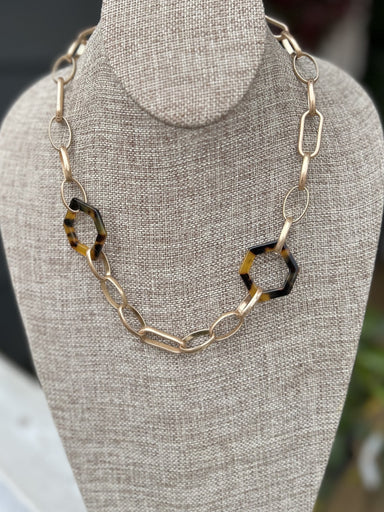 Sculpt a stylish look with this unique necklace. Crafted with large gold chain links, it's adorned with tortoise-colored hexagon links for a timelessly fashionable look. Add an eye-catching flair to any outfit with this gorgeous piece.   Approximate Length: 18-21"