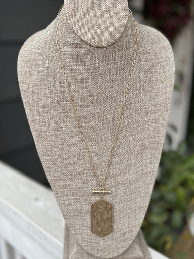 This beautiful long gold necklace sparkles with a unique hammered gold charm. Crafted with a paperclip chain, this piece is perfect for casual or dressy pieces. This would be beautiful with your favorite winter sweater!  Approximate Length: 34-36"