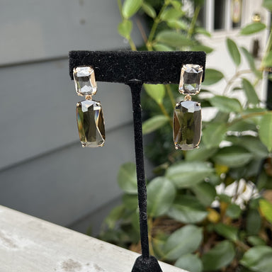 Sparkle and shine with these elegant Emerald Cut Post Earrings! The post earrings feature a clear emerald shape with a larger smoky emerald shaped drop.