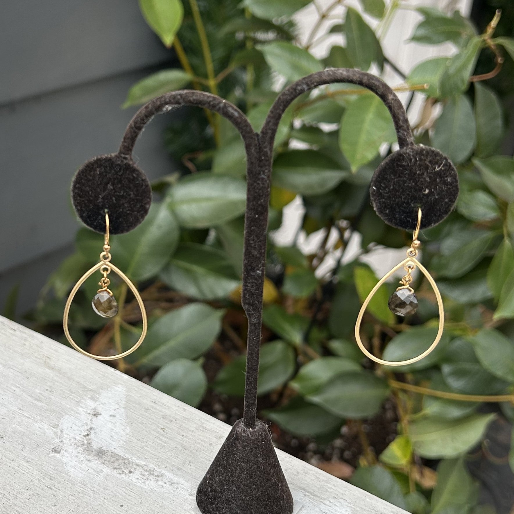 These dainty Gold Teardrop Earrings are the perfect combination of elegance and luxury. The beautiful teardrop shape with a dark gray/brown stone is a timeless classic that will never go out of style. Wear them for any special occasion and feel your best.