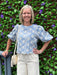 You will love this charming blue and white embroidered top. Delicate embroidery adorns the fabric, while elbow-length sleeves offer a refined silhouette. The scalloped hem adds a feminine touch that pairs beautifully with white jeans, white shorts, or linen pants. A versatile piece that transitions effortlessly from day to evening, this top brings understated elegance to any outfit.

Barbara is wearing a size Small.

Material: 100% Cotton

Care Instructions: Gentle cool hand wash cold, dry flat
