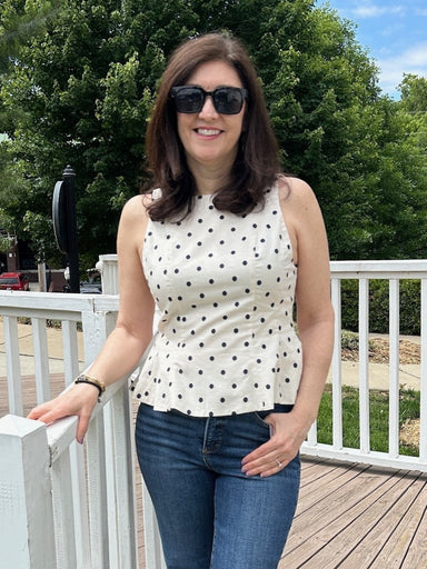 This sleeveless peplum top combines timeless style with modern flair. The cream base adorned with classic black polka dots creates an effortlessly chic aesthetic, while the flattering peplum silhouette adds dimension and curves beautifully to your frame. Fully lined for comfort and confidence, this stunning piece transitions seamlessly from casual outings to special occasions. Perfect for pairing with tailored trousers, skirts, or jeans, it's a versatile wardrobe essential that delivers both elegance and co