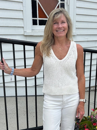 A timeless staple that transitions effortlessly from day to night. This V-neck knitted tank features a luxuriously soft construction in a creamy white that complements every skin tone and pairs with virtually anything in your closet. The sleeveless design and flattering V-neckline make it perfect for layering under blazers or cardigans, or wearing solo on warmer days. Dress it up with tailored trousers or keep it casual with your favorite denim. Add one of our signature skinny scarves to elevate the look in