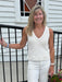 A timeless staple that transitions effortlessly from day to night. This V-neck knitted tank features a luxuriously soft construction in a creamy white that complements every skin tone and pairs with virtually anything in your closet. The sleeveless design and flattering V-neckline make it perfect for layering under blazers or cardigans, or wearing solo on warmer days. Dress it up with tailored trousers or keep it casual with your favorite denim. Add one of our signature skinny scarves to elevate the look in