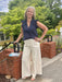 Effortless comfort meets timeless style with these wide-leg pants in soft butter cream. Featuring an adjustable elastic and drawstring waist for a custom fit, front pockets for practicality, and striking vertical stitching details that add visual interest. The relaxed silhouette flatters all body types and pairs seamlessly with everything in your wardrobe—from fitted tops to oversized sweaters. Perfect for casual days when you want to look put-together without sacrificing comfort.

Barbara is wearing a size