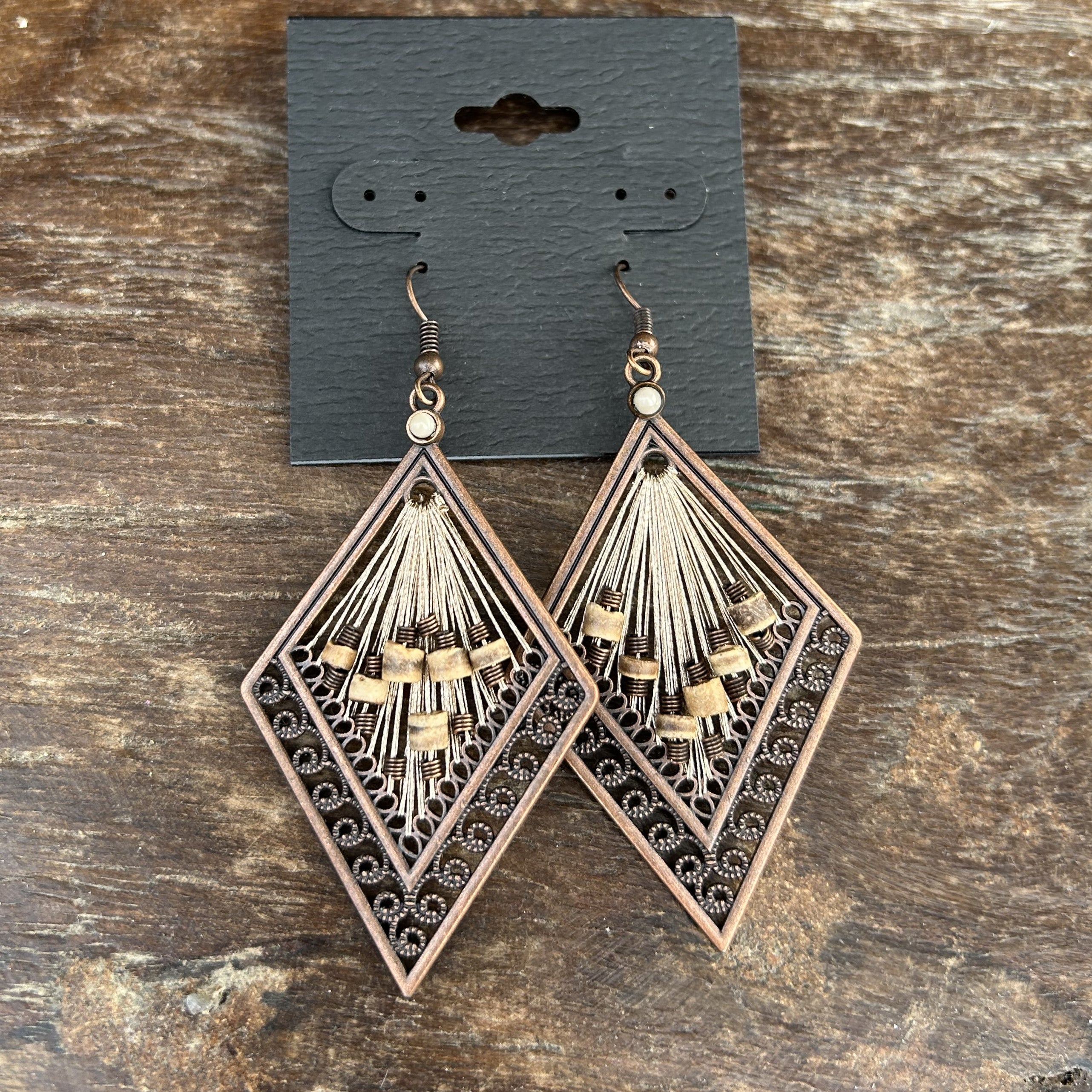 Add a touch of chic elegance to your outfit with these beautiful Geometric Bronze Metal Earrings! Featuring stylish center tubular stones, these earrings are sure to be a stunning addition to your jewelry collection. You will love the way they look and feel when wearing them, making them a must-have accessory for any occasion.