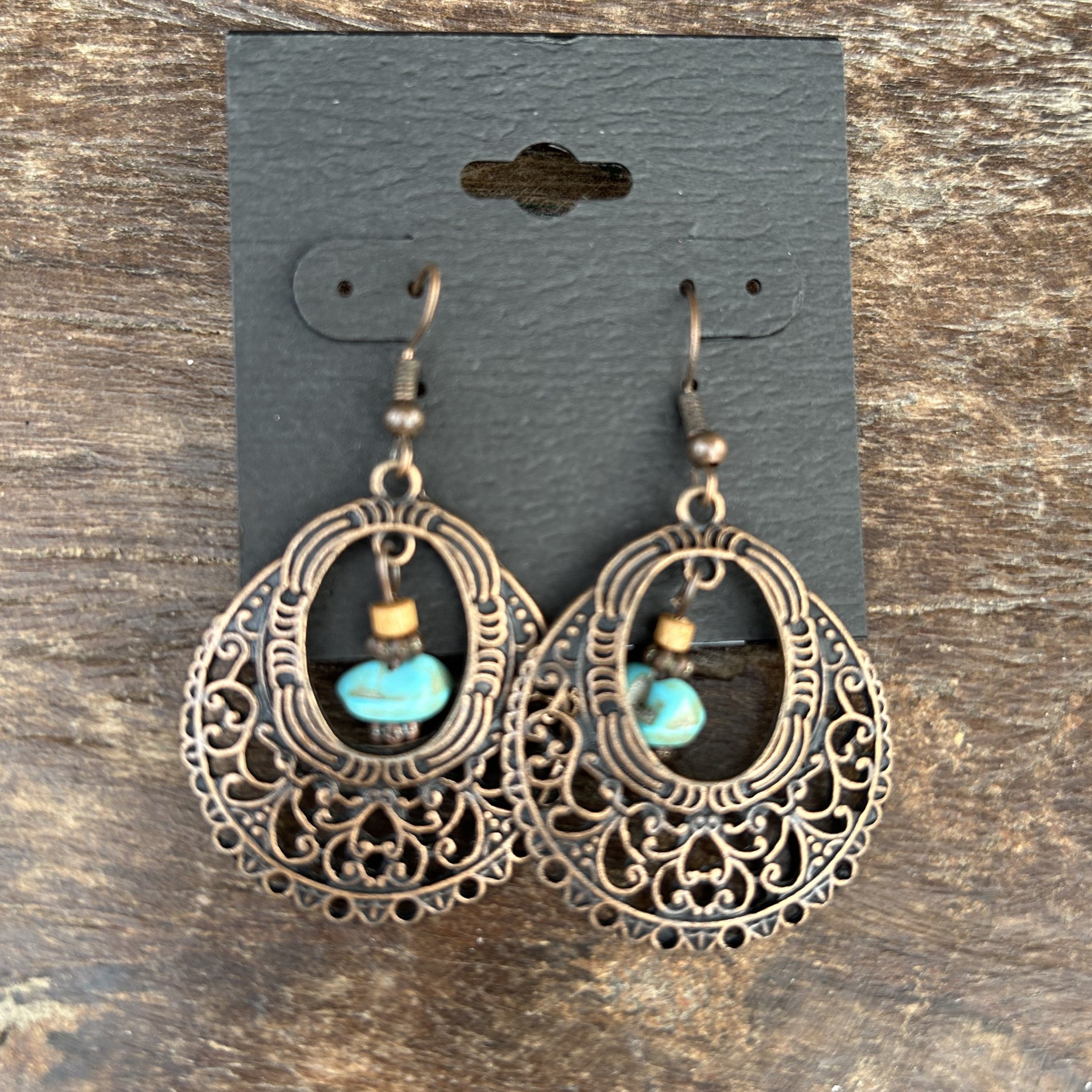 Add a touch of elegance to your outfit with these stunning Ornate Bronze Metal Round Earrings! The beautiful round design and stylish center turquoise stone make these earrings a beautiful combination. The ornate bronze color adds a touch of sophistication to any look.