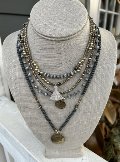Add a touch of bohemian elegance to your wardrobe with our Five Strand Boho Necklace! It has a unique and stunning look with shades of denim blue and gold beads. It's a beautiful statement piece you will love!  Approximately 14-16" in length.
