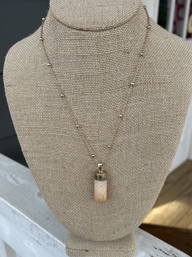 Add a touch of elegance to any outfit with our Gold Necklace w/ Stone Pendant! This chain necklace with interspersed gold beads features a stunning colored stone pendant, making it the perfect statement piece for any occasion – dressy or casual.  Approximate length: 18-21"
