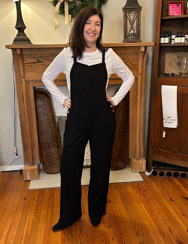 Black corduroy overalls with white long sleeve T shirt. 