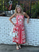 Carolee is wearing a red & Ivory print sundress with a cute white bag and sandals. The midi dress has an awesome print. rushing in the back and spaghetti strapts.  She is wearing a small.