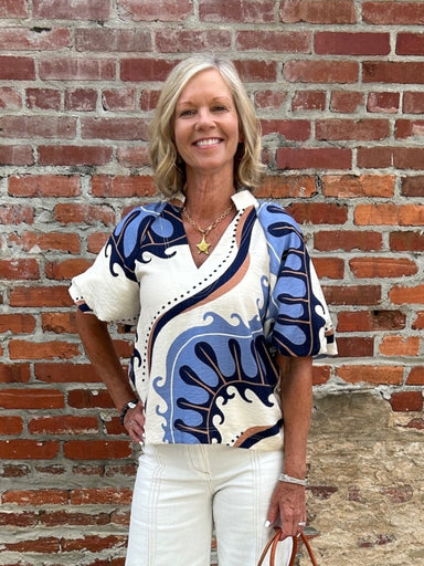 This Abstract Print Top is designed for those who appreciate artistic expression in their everyday wardrobe. Set against a soft cream canvas, the bold abstract print commands attention while remaining effortlessly wearable. Puff sleeves add a touch of romance and dimension, while the V-neck with placket collar keeps the look modern and refined. Style it with coordinating cream pants for a cohesive, polished appearance, or pair with denim for an approachable, laid-back vibe. A versatile piece that transition