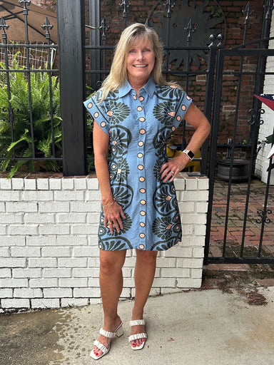Effortlessly transition from day to night in this abstract floral print dress. The medium blue background is beautifully accented with black and coral tones, creating a striking visual appeal. Featuring a classic button-up front with placket, cap sleeves, and traditional collar, this lined dress offers both comfort and style. Perfect for casual outings or dressed up for special occasions.

Carolee is wearing a size XSmall.

Material: 83% Rayon / 17% Linen

Care Instructions: Gentle cool hand wash, dry flat