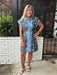 Effortlessly transition from day to night in this abstract floral print dress. The medium blue background is beautifully accented with black and coral tones, creating a striking visual appeal. Featuring a classic button-up front with placket, cap sleeves, and traditional collar, this lined dress offers both comfort and style. Perfect for casual outings or dressed up for special occasions.

Carolee is wearing a size XSmall.

Material: 83% Rayon / 17% Linen

Care Instructions: Gentle cool hand wash, dry flat