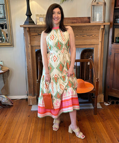 Beautiful maxi halter dress with a tiered skirt in a santa fe print. It has a cream backtground with green pink and orange print. The fabric is lovely and travels well.