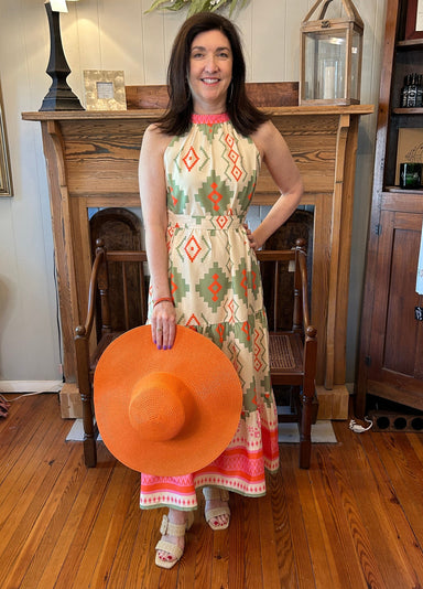 Midi halter dress with a Santa Fe print in green, orange and hot pink. Paired with an orange sun hat it's perfect for Derby Day, an afternoon wedding or and summer affair. 
