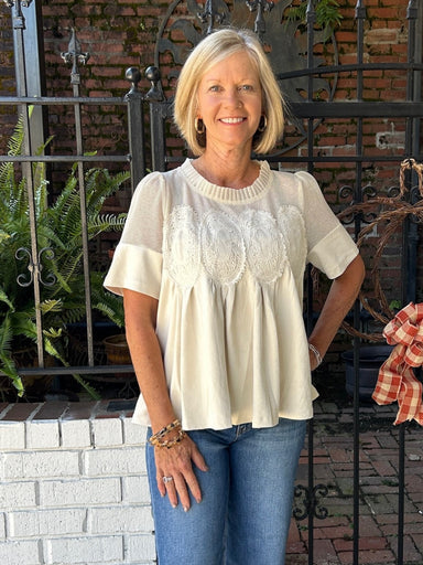 This ivory blouse combines delicate lace applique with soft faux sueded fabric for a versatile piece that transitions seamlessly from casual to dressy occasions. The unique texture pairing and intricate detailing make it a standout addition to any wardrobe.

Barbara is wearing a size Small.

Material: 92% Polyester / 8% Spandex; Contrast: 65% Cotton / 35% Polyester&nbsp;

Care Instructions: Hand wash separately in cold water, hang to dry