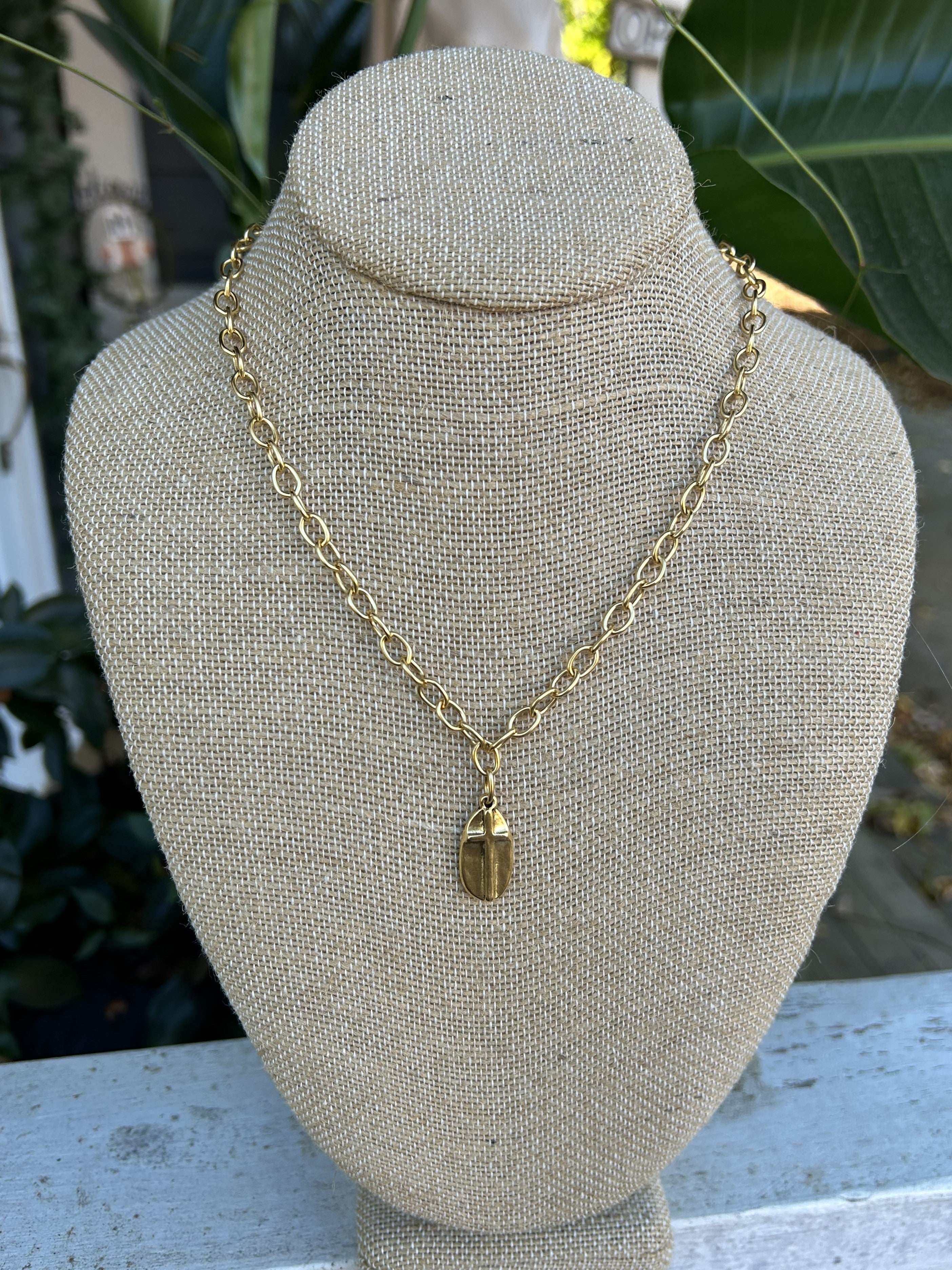 This is a lovely short gold necklace with a oval shaped cross pendant! The cross pendant is oval-shaped and has a raised but hammered look. It's a beautiful combination you will love!

Approximate length: 19"