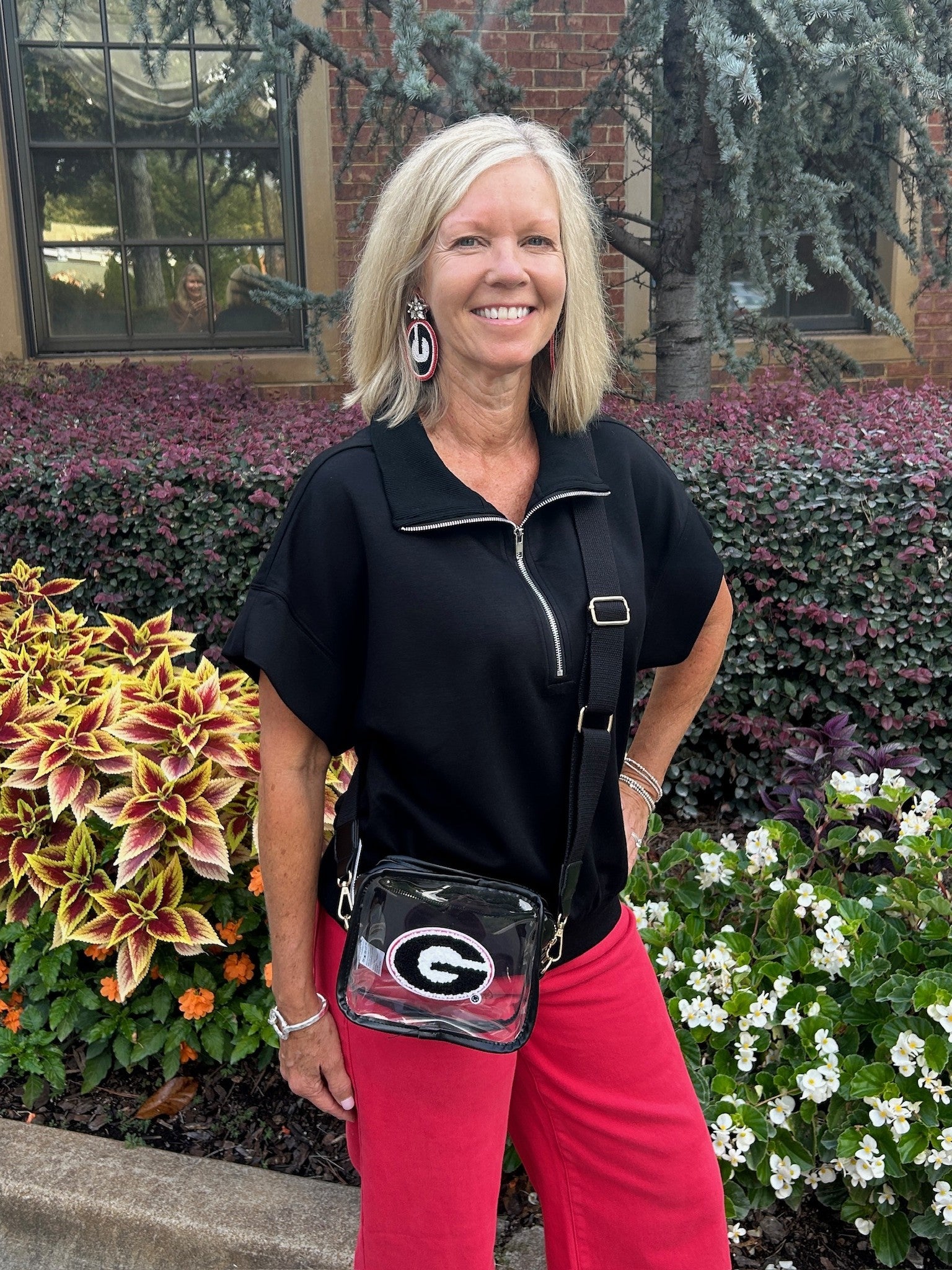 Experience effortless comfort with this Casual Zip Front Top. Featuring a soft, black fabric, a convenient zip-up front, and a relaxed drop shoulder with cap sleeves, it offers a flattering yet easy fit. The banded waist and collar add subtle shape, making it perfect for casual wear or travel.&nbsp;

Pair with our matching "Pull On Sweatpants".

Barbara is wearing a size Small. She paired the top with our "Risen High Rise-Crop Wide Pants in Scarlet Red. She accessorized with our "Clear Georgia "G" Game Day 