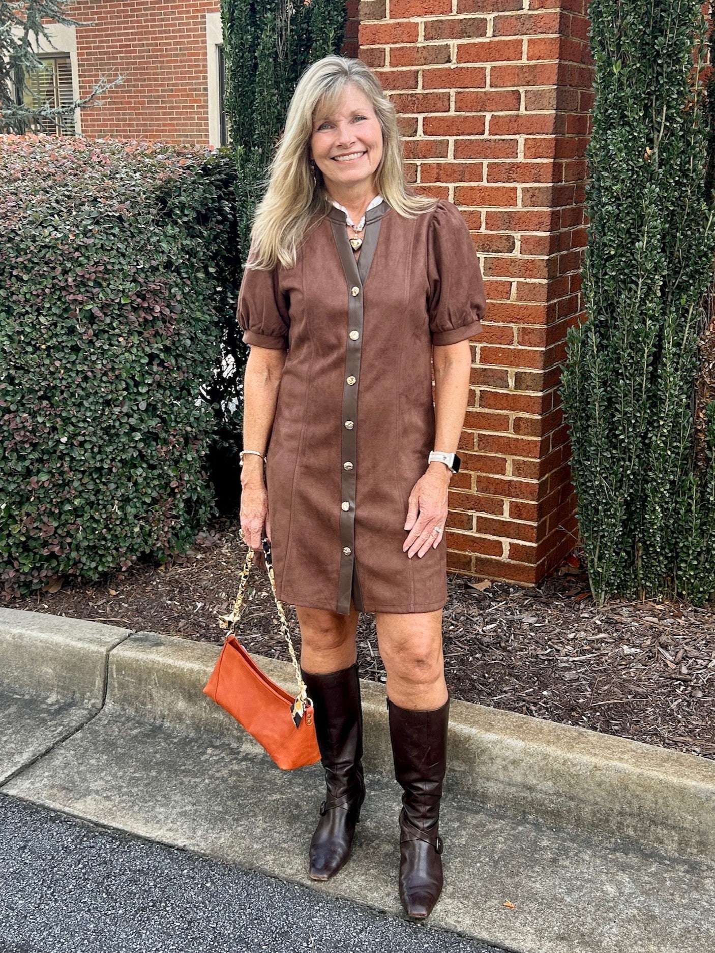 This Puff Sleeve Button Up Dress blends style and comfort effortlessly. Featuring a button-up front and sleek faux leather trim, it’s enhanced with detailed stitching down the front for a refined look. The slight flair complements your figure while the ultra-soft fabric feels gentle against the skin. Cuffed puff sleeves add a trendy, feminine touch. Perfectly paired with your favorite boots or heels, this dress is your go-to piece.

Carolee is wearing a size Small. She accessorized with our "Scarf Necklaces