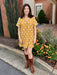 Stand out at GA Tech events in this Short Sleeve V-Neck Dress, crafted from textured material with a beautiful mustard color. The dress features tufted, contrasting detailing and a faux leather trim around the neck for a polished finish. Fully lined for comfort, it combines style and sophistication effortlessly, making it a perfect choice to showcase your college spirit with elegance.

Tara is wearing a size Medium. She added our "Maryna Chain Link Cross Necklace".

Material: 100% Cotton

Care Instructions: