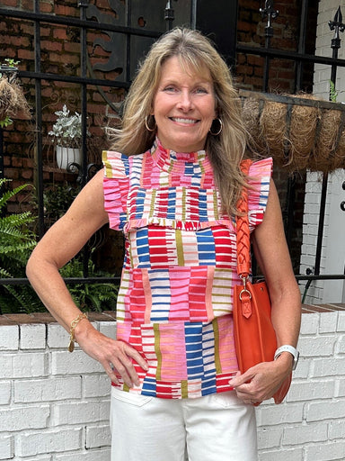 This Smocked Bodice Ruffle Sleeve Top is perfect for any occasion. It features vibrant colors of pink, red, blue, green and peach, as well as a smocked bodice and ruffled neck and sleeves for a unique and stylish look. It's sure to brighten up any wardrobe.  Carolee is wearing a size small.  Material: 100% Cotton  Care Instructions: Gentle cool hand wash, dry flat in shade
