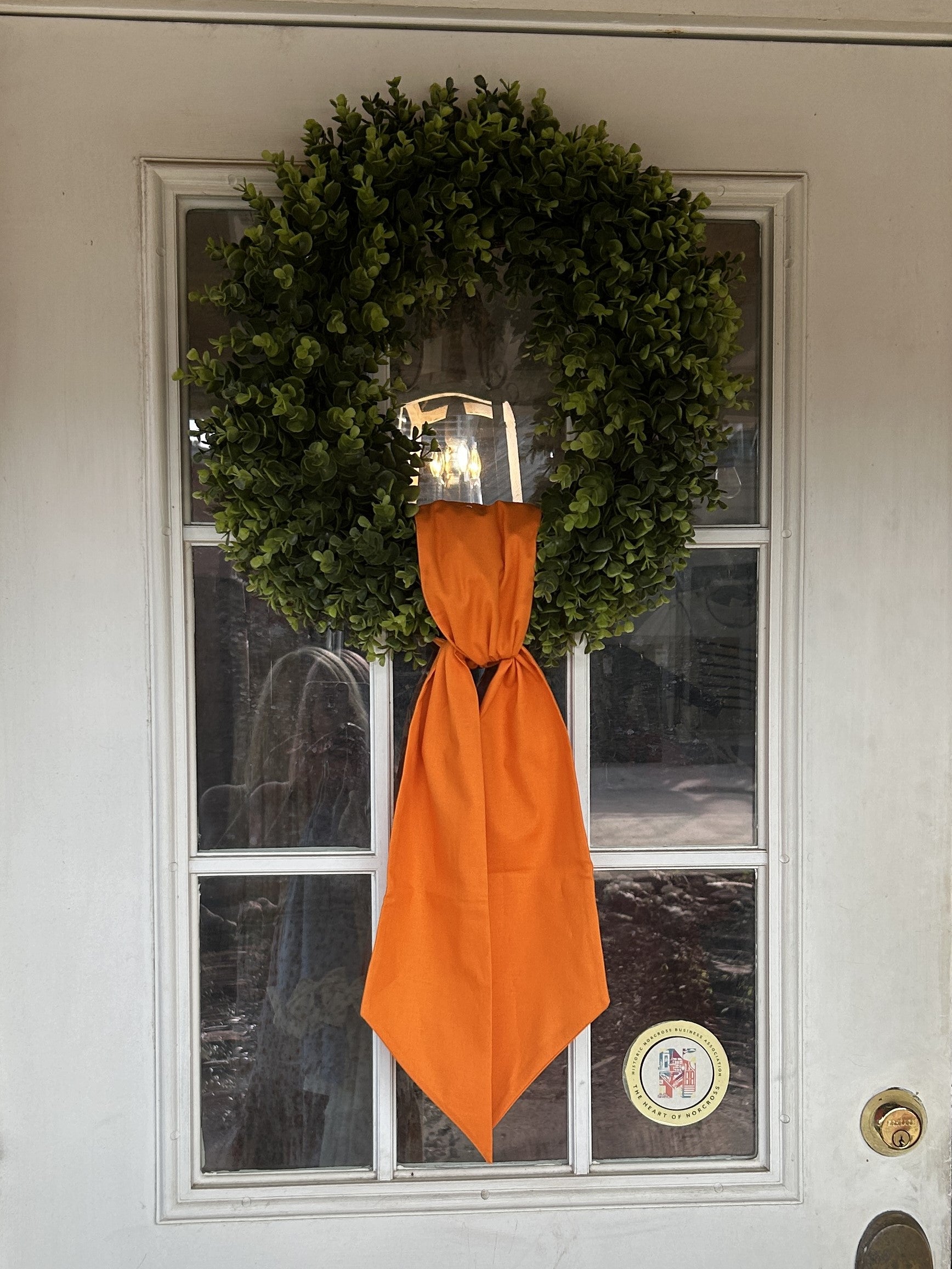 The addition of this beautiful round 20" boxwood wreath is the perfect accent piece for your home. Use this wreath all year long for some added greenery to your home. Covered in lush vibrant preserved boxwood leaves, on a thick vine base, enjoy this wreath season after season.  Sashes are not included but you can add our beautiful wreath sashes to your boxwood wreath to celebrate game day or different seasons of the year!