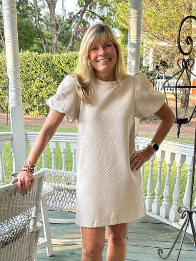 You will love this simple but Textured Puff Sleeve Mini Dress! With its unique geometric design, this top is sure to add a flare to any outfit. The cute puffed sleeve, side slit pockets and lovely sand color make it a versatile staple for any occasion. Dress it up or wear it casual, this dress is a must-have in your wardrobe!  Material: 95% Polyester / 5% Spandex  Care Instructions: Hand wash cold, line dry