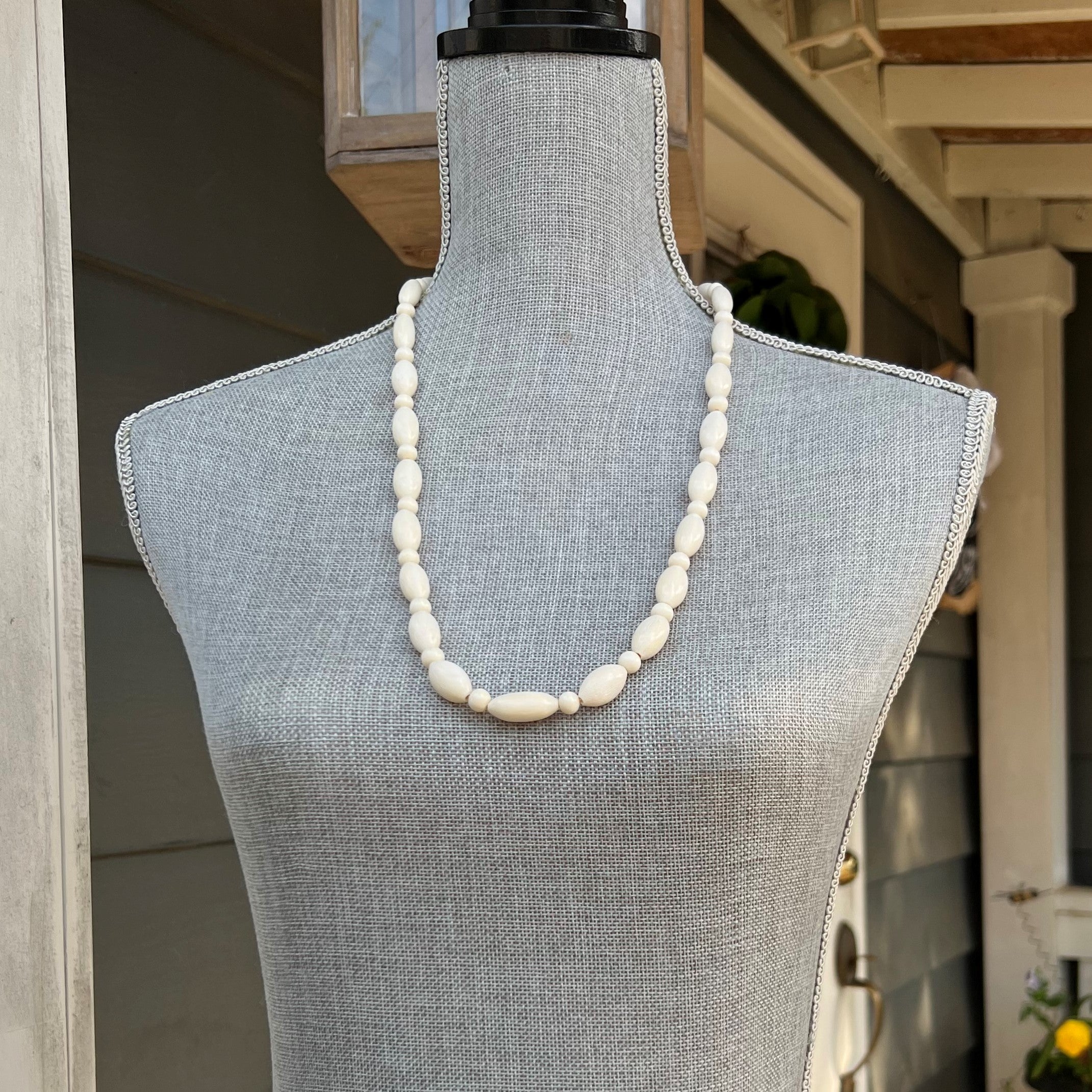 This luxurious necklace is handcrafted with camel bone beads. The beads alternate between oblong and round shapes giving the necklace a unique look. The sophisticated materials make this necklace an exquisite addition to any wardrobe. The approximate length is 28".