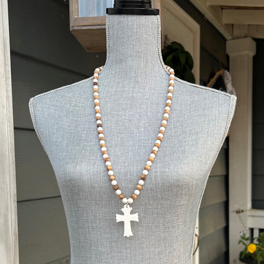This luxurious necklace is handcrafted with camel bone and olive tree wood beads and detailed with an intricately hand-carved cross. The sophisticated materials make this necklace an exquisite addition to any wardrobe. The approximate Lengths of this necklace is 32".